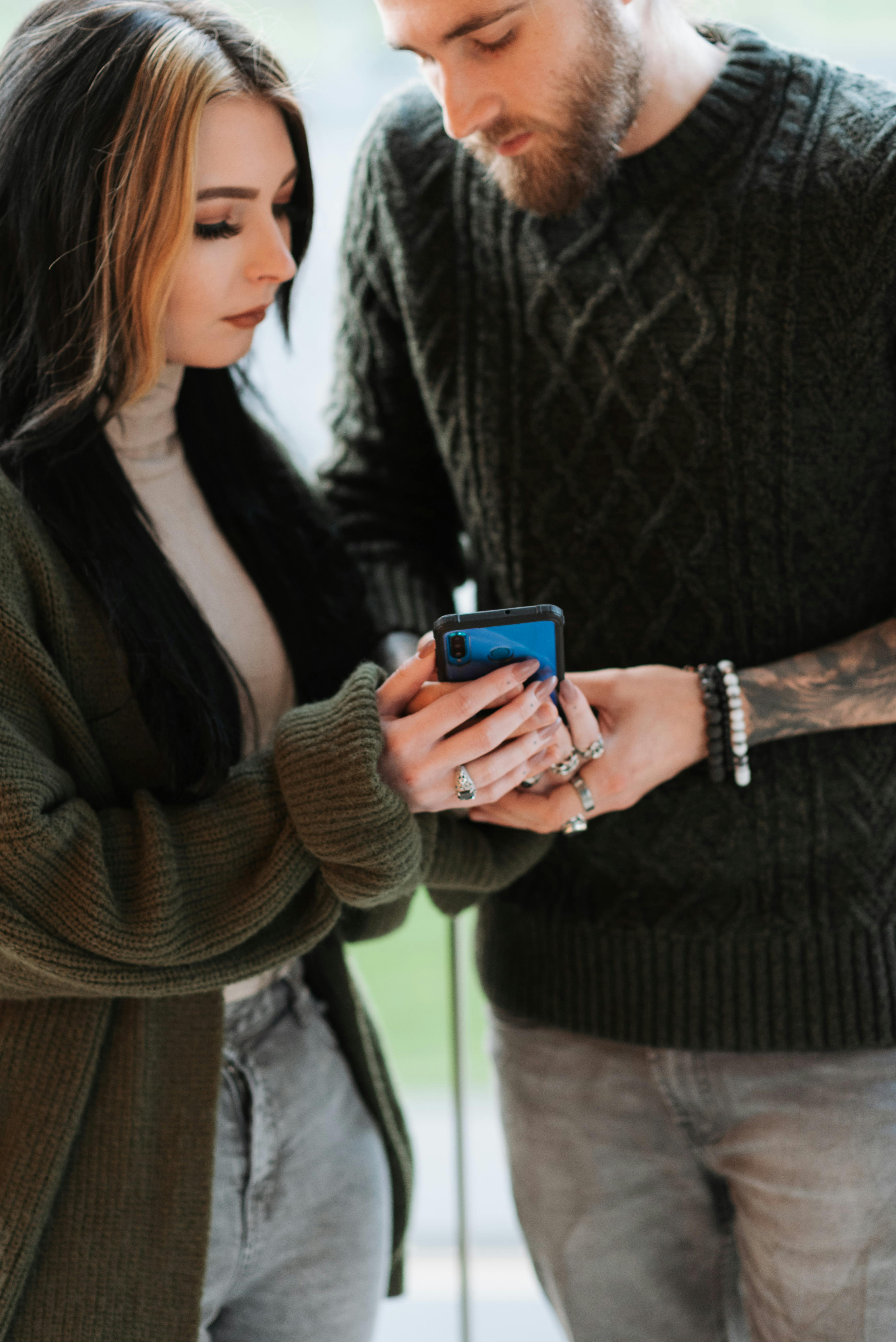 crop couple browsing internet on smartphone on balcony