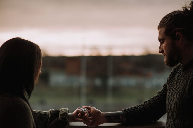 Crop Couple Holding Hands On Balcony At Sunset