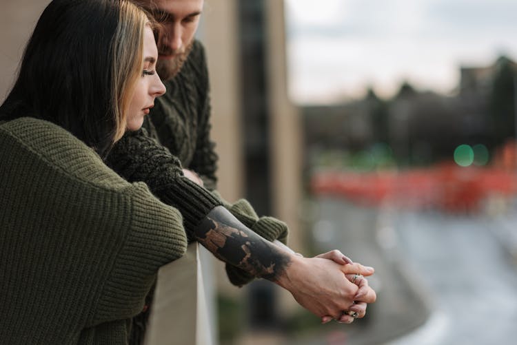 Crop Couple Holding Hands On Balcony In City