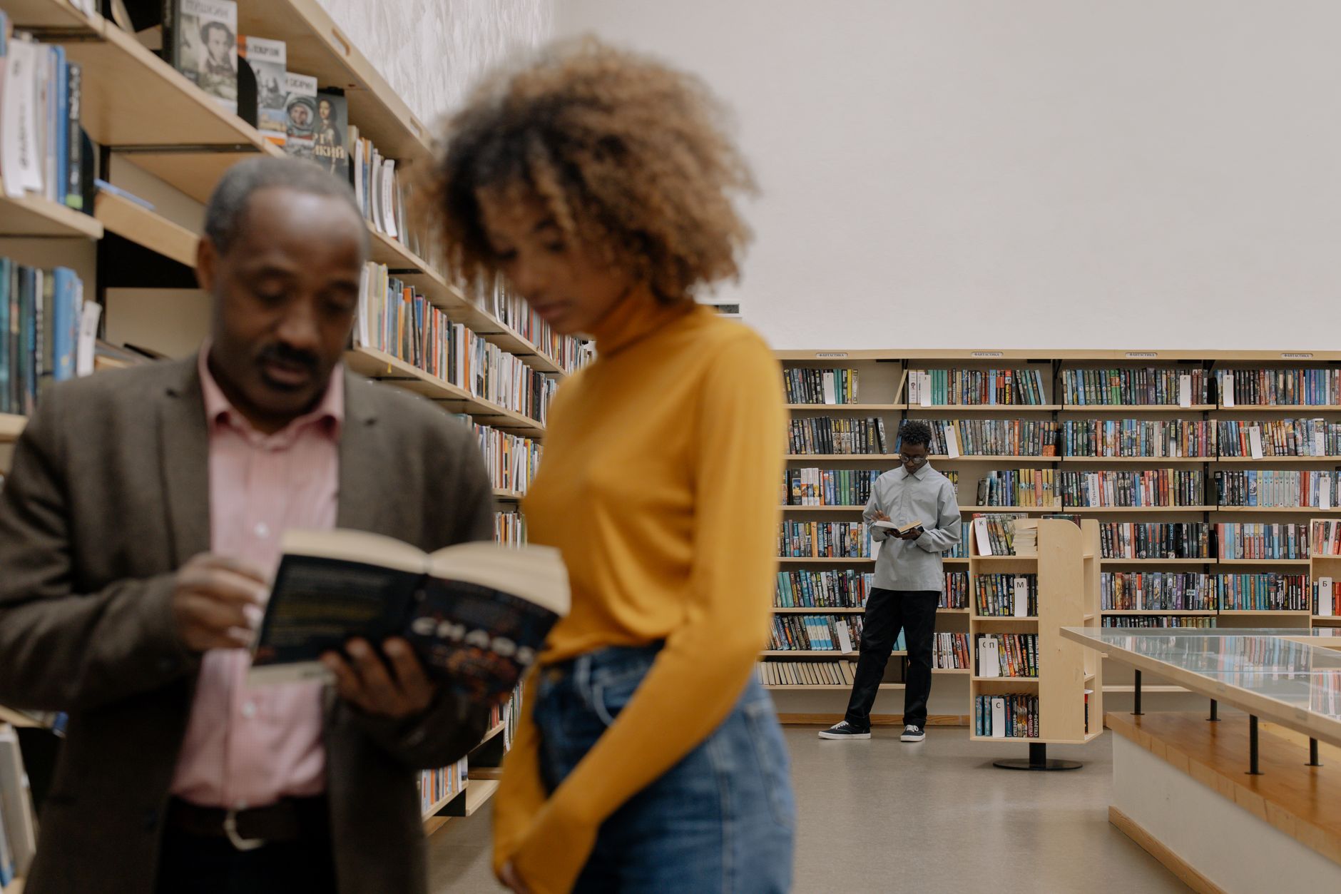 Mensen lezen en studeren in een moderne bibliotheek omgeving, waarbij educatie en diversiteit worden bevorderd.