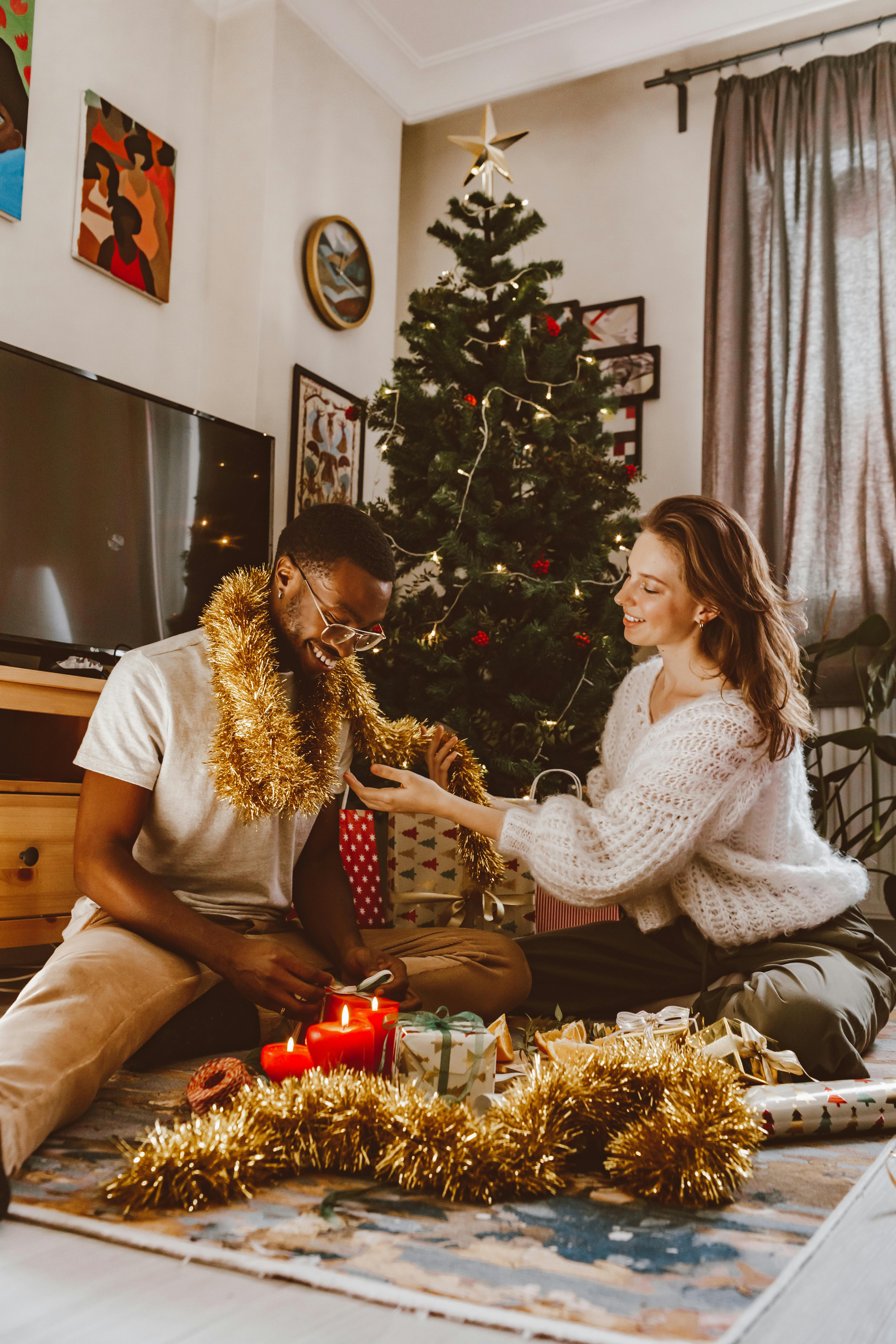 a woman wrapping a man in gold garland