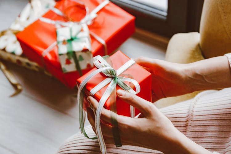 A Person Holding A Christmas Presents