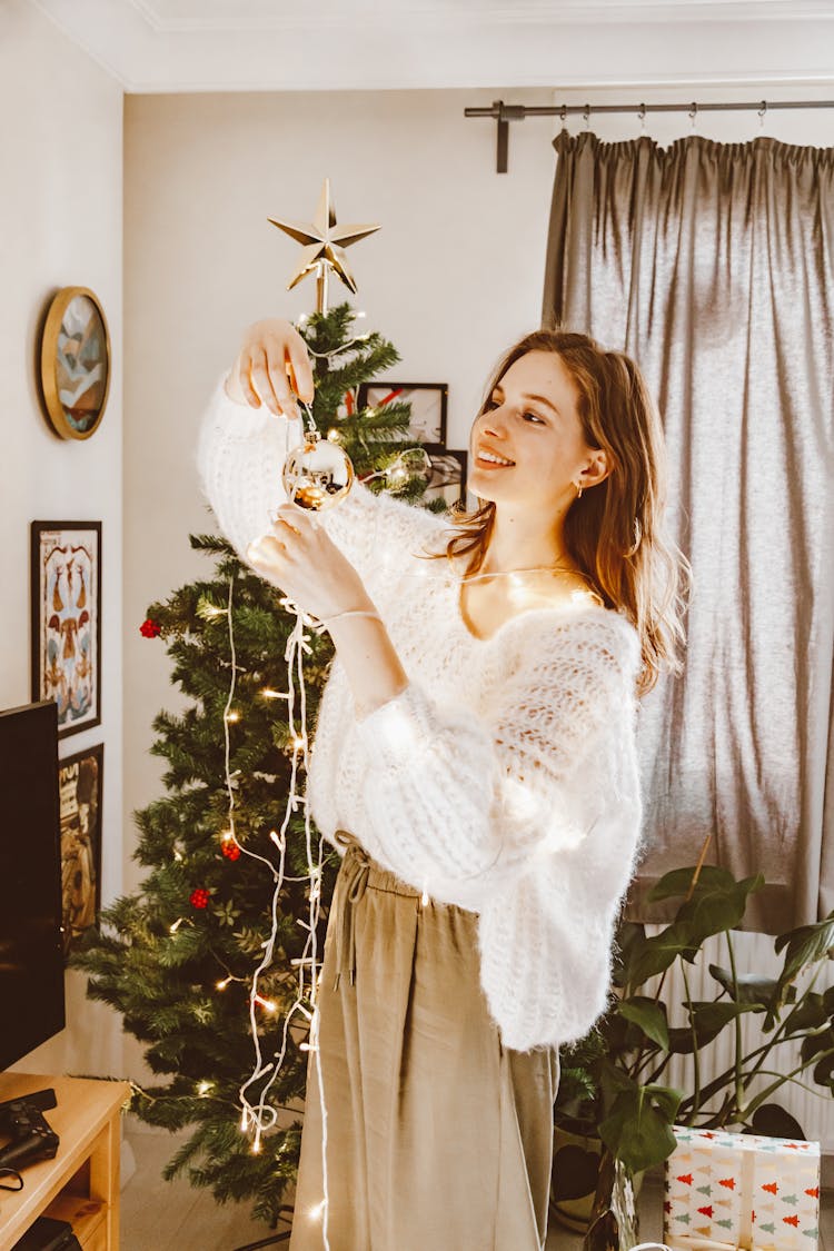 A Woman Holding A Gold Bauble