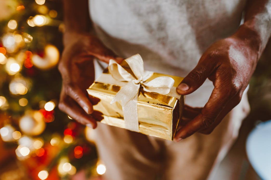 Free Person Holding a Gold Gift Box Stock Photo