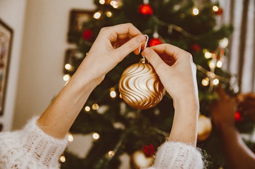 Free A Person Holding a Gold Bauble Stock Photo