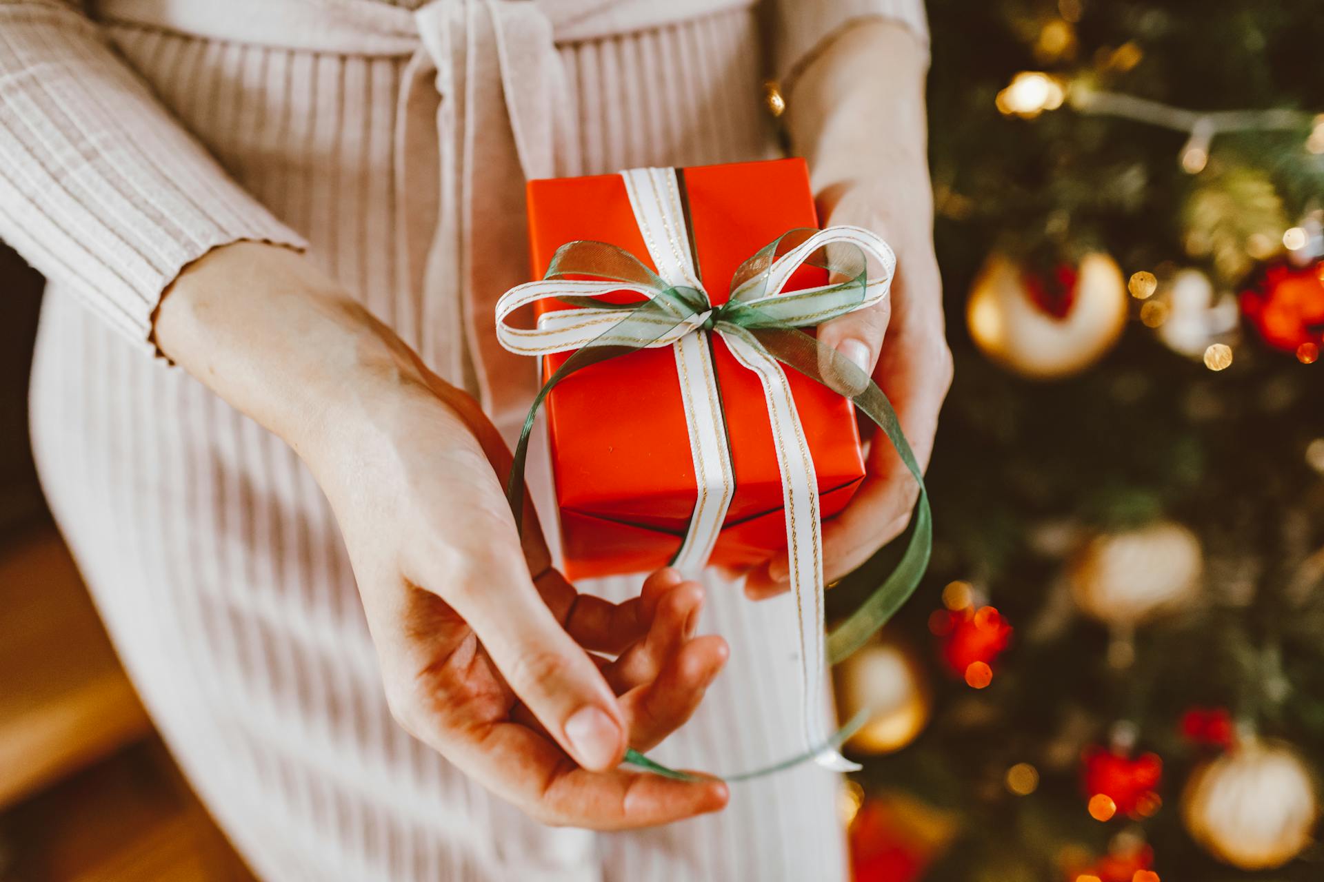 A Woman Holding Red Gift Box with Green and White Ribbon