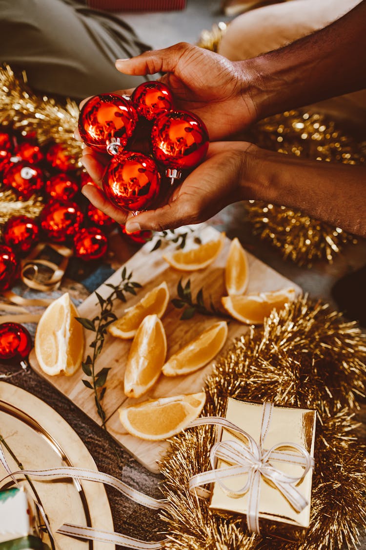 Hands Holding Decorations And Fruit On Tray