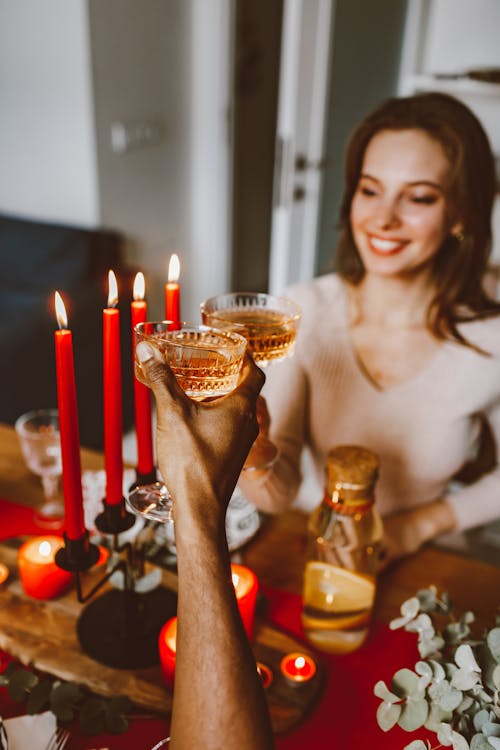 Woman in White Tank Top Holding Red Candles