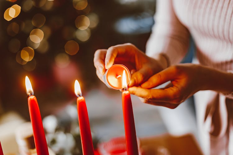 Woman Lighting Candles During Christmas