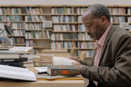 Man in Black Suit Reading Book