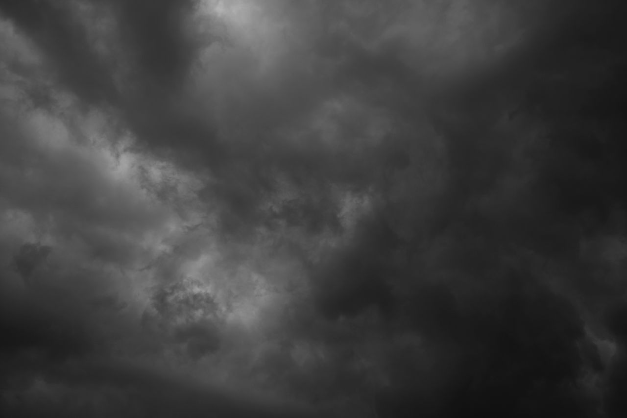 a dynamic and moody black and white shot of storm clouds filling the s