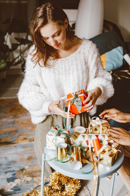 Woman Wearing Knitted Sweater Holding Gift 