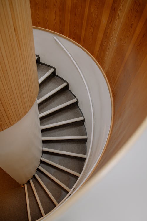 Free Wooden Spiral Staircase With Brown Wooden Wall Panel Stock Photo