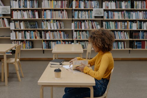 Woman in Yellow Long Sleeve Shirt Sitting on Chair