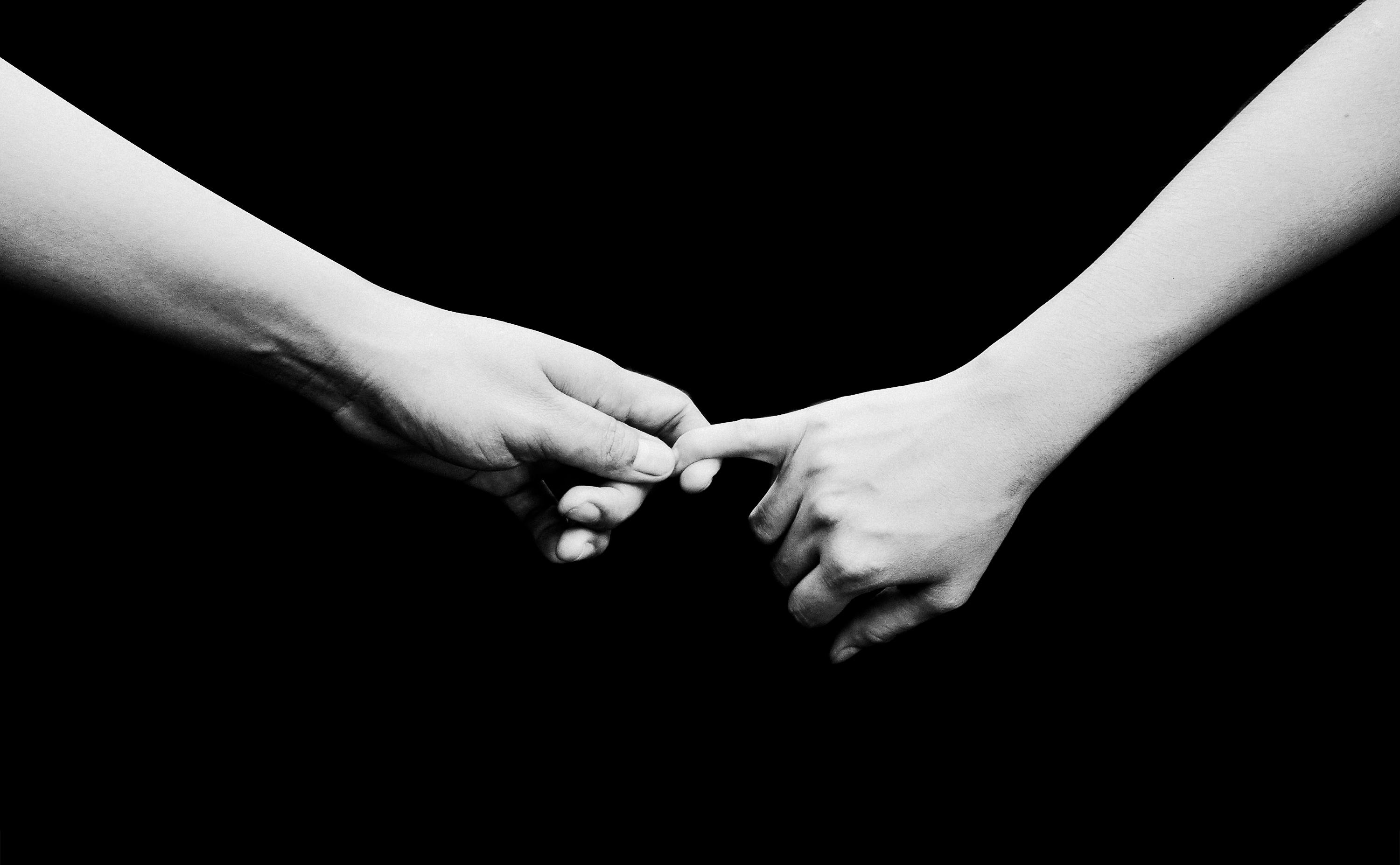 two people holding hands black and white