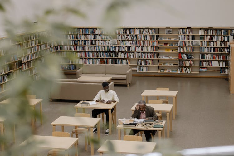 Men Sitting And Reading At Library