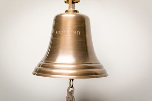 特写镜头中，室内悬挂的抛光铜钟上刻有文字