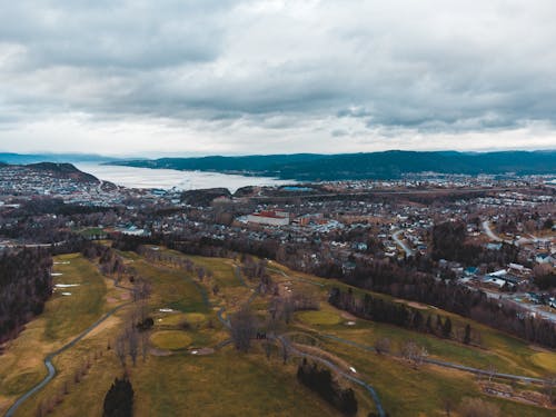 Breathtaking scenery of coastal town and grassy terrains under overcast sky