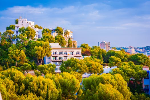 Beautiful hillside villas surrounded by greenery under a vibrant sky.