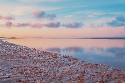 Body of Water with Rocky Shore under an Evening Sky