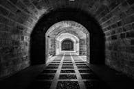 这张黑白照片展现了哥特式石隧道的拱门和复杂建筑特色