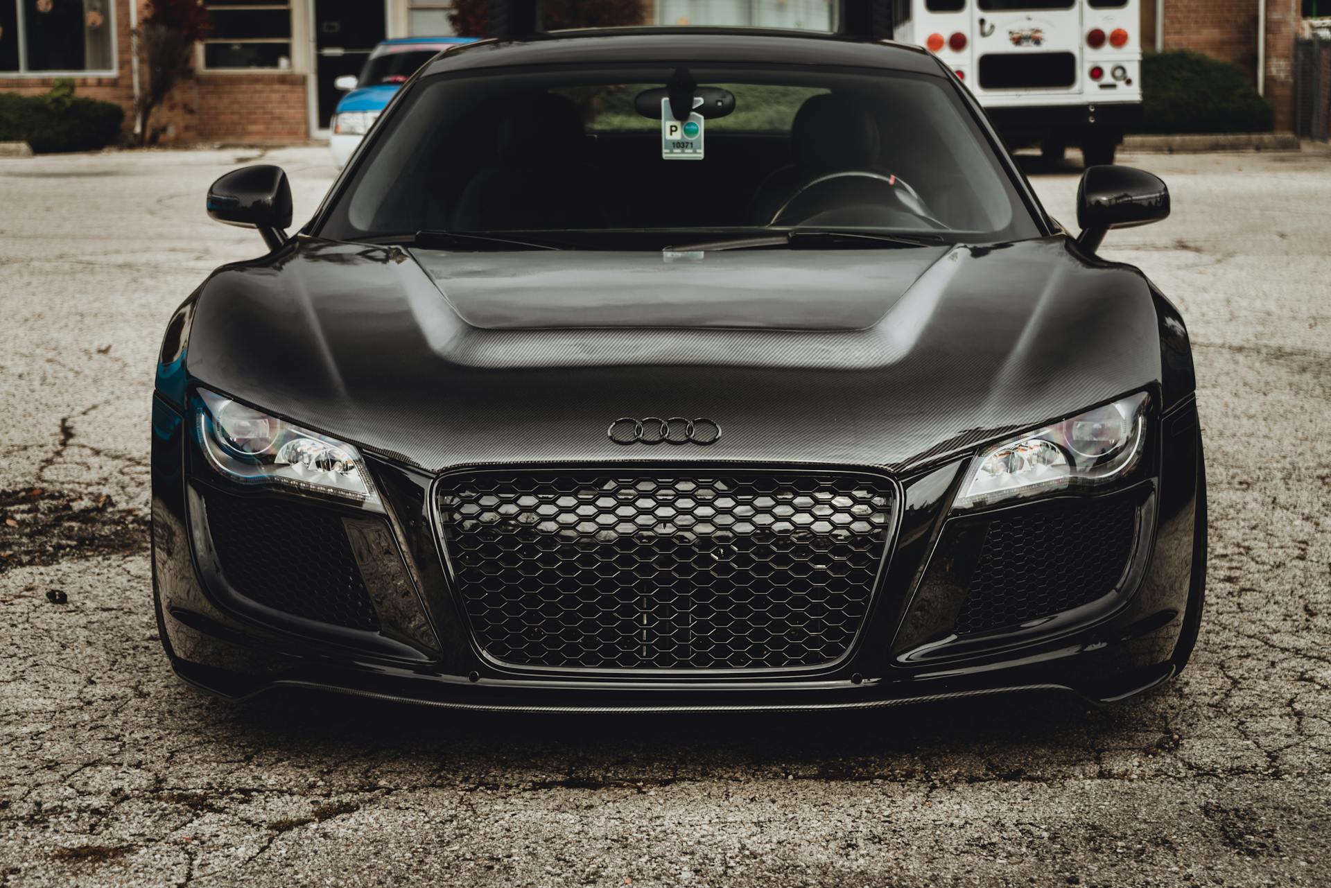 Front view of a luxurious black Audi R8 sports car parked in an urban setting.