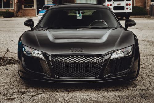 Free Front view of a luxurious black Audi R8 sports car parked in an urban setting. Stock Photo