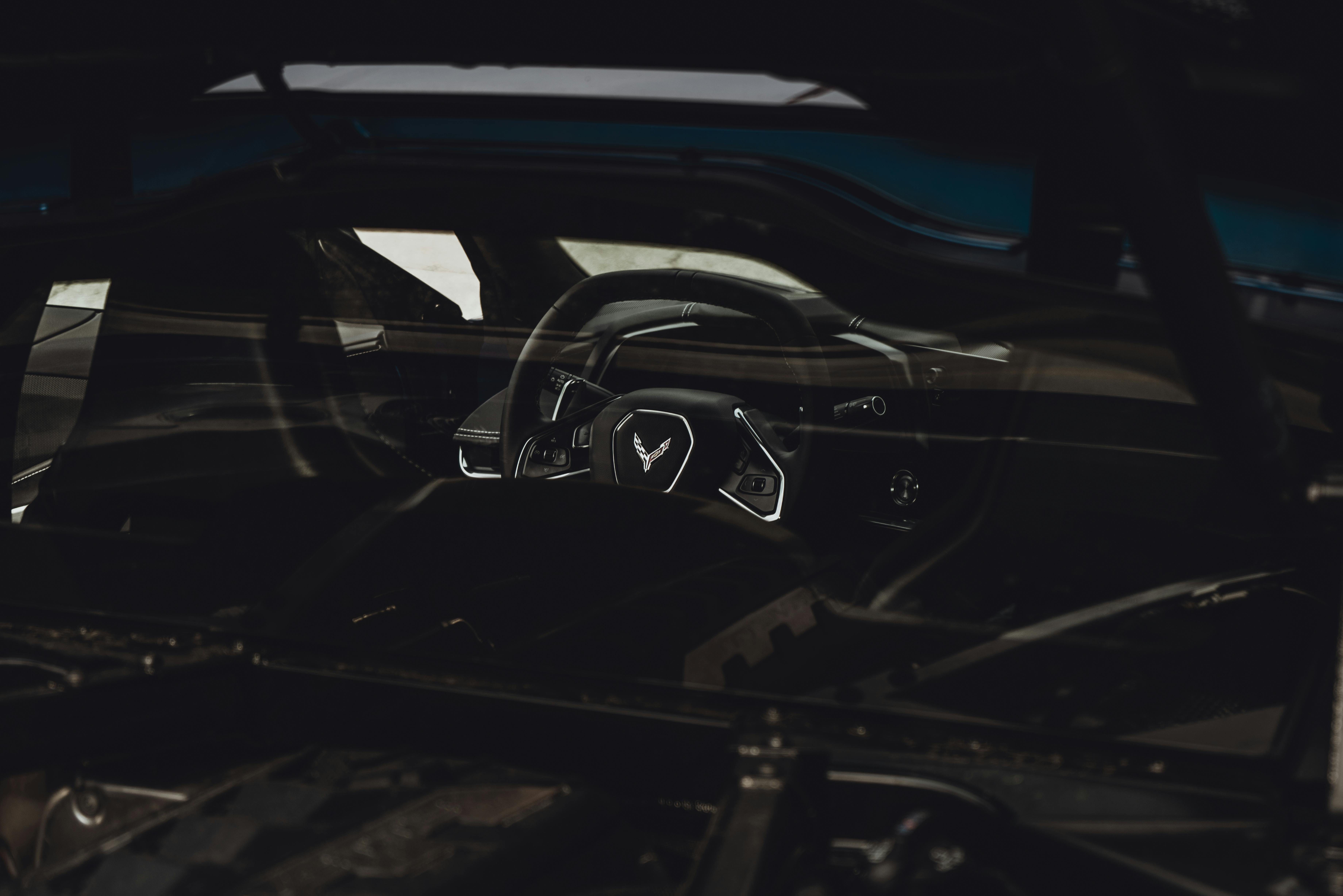 Dark image highlighting the steering wheel of a Chevrolet Corvette, emphasizing luxury and sportiness.