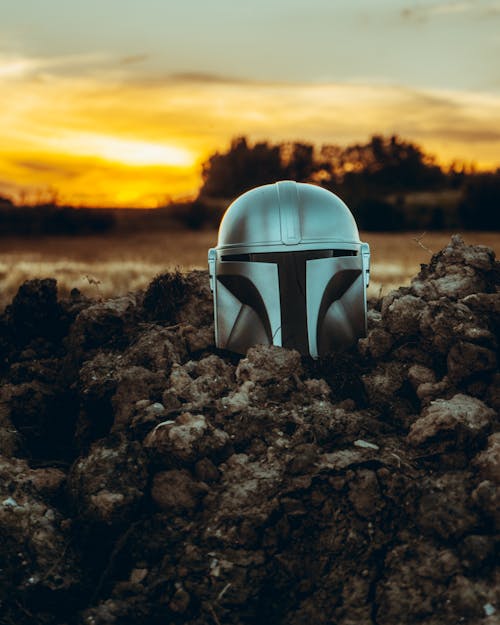 Mandalorian Helmet on Brown Soil during Sunset