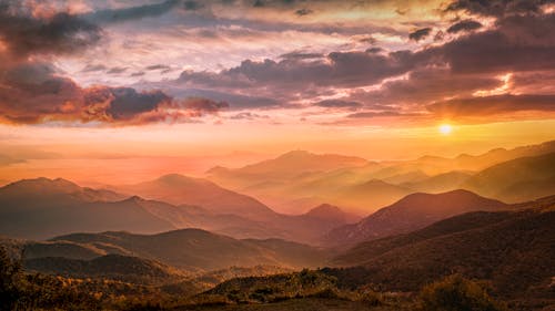 白い雲の下の緑の山々