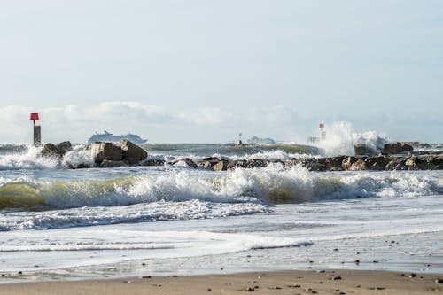 Sea Waves Crashing on Rocks Under Clear Sky