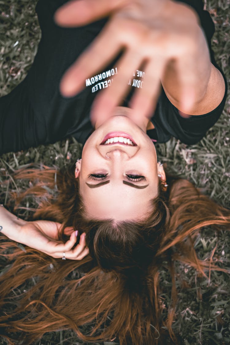 Happy Woman Showing Stop Gesture While Resting On Grass