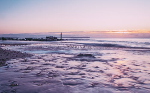 Body of Water Under Clear Evening Sky