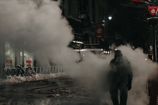 Anonymous person in warm wear walking through street steam in modern NYC district in winter evening