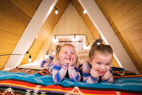 Free Girls Lying on the Bed in the Attic Stock Photo