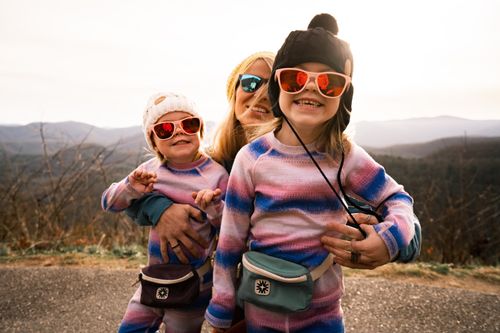 Free Family enjoying a sunny day outdoors in Asheville, NC, with kids wearing colorful outfits and sunglasses. Stock Photo