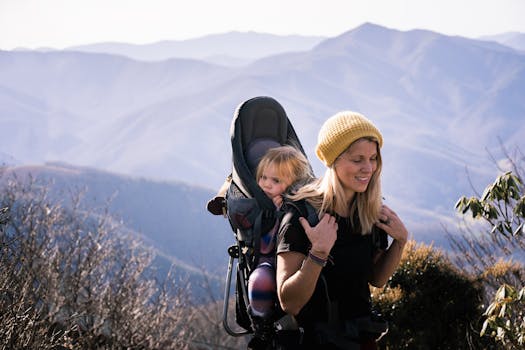 A mother carrying her daughter on a hike in Asheville's Blue Ridge Mountains.