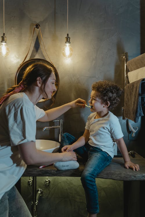 Woman Brushing a Boy's Teeth