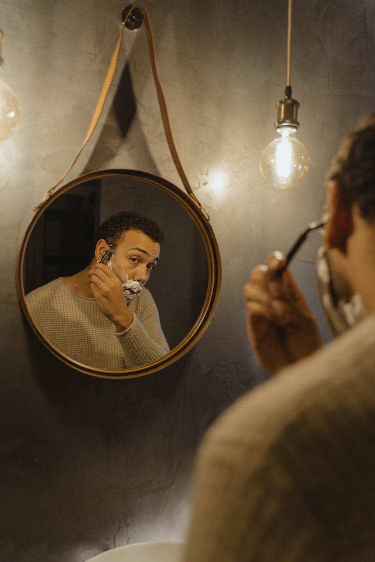 Man Shaving In Front Of Mirror