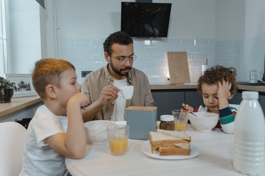 A father and his two young sons sharing a breakfast moment at home.
