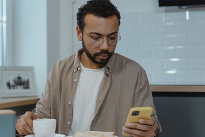 Man using a phone at breakfast