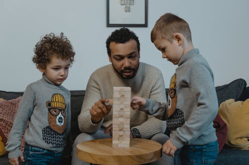 Free A Man Playing a Wooden Blocks with His Kids Stock Photo