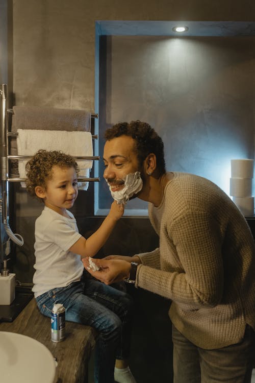 Free Boy Playing with Shaving Cream on a Man's Face Stock Photo