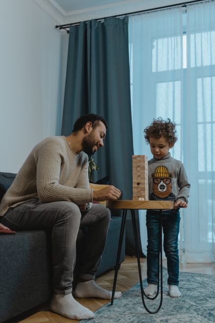 A father and son building a Jenga tower together, fostering creativity and bonding.