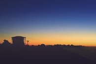 工业工厂的轮廓映衬在充满活力的日出天空和云层中