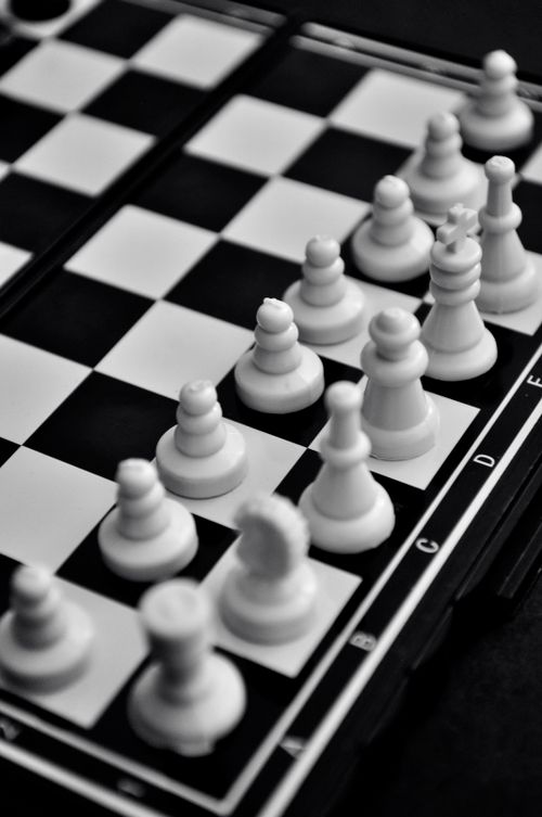 Free High-angle view of chess pieces on a chessboard showing strategy and tactics. Stock Photo