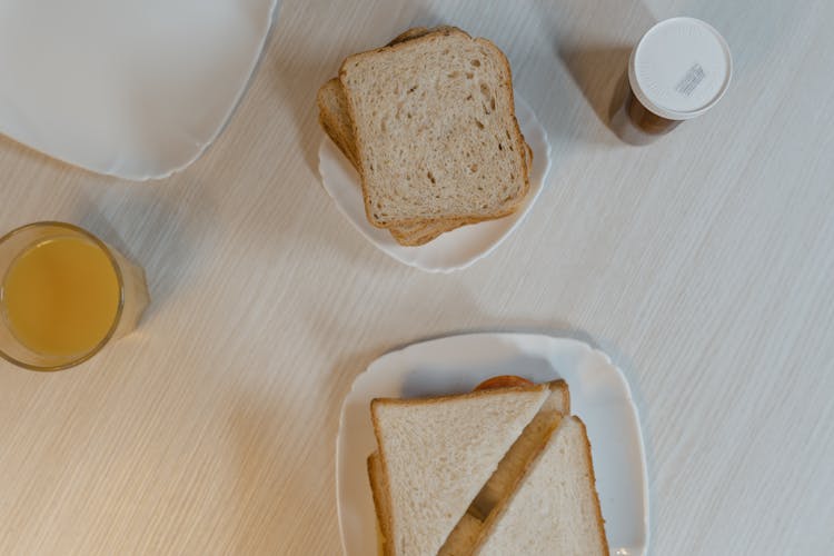 White Bread And Sandwich On White Ceramic Plates