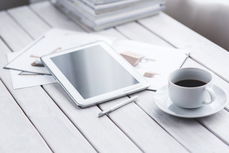 White tablet and cup of coffee