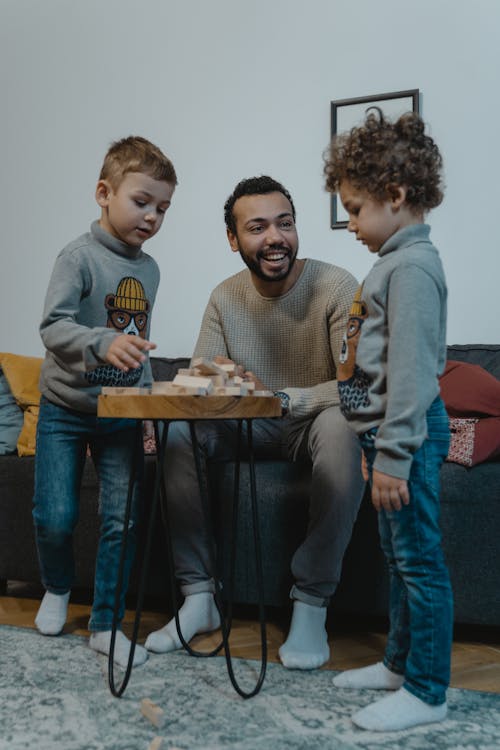 Free Man and Two Boys Playing with Wooden Blocks Stock Photo