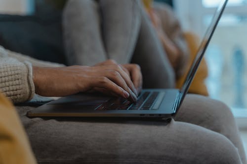 Person Typing on the Keyboard of a Laptop